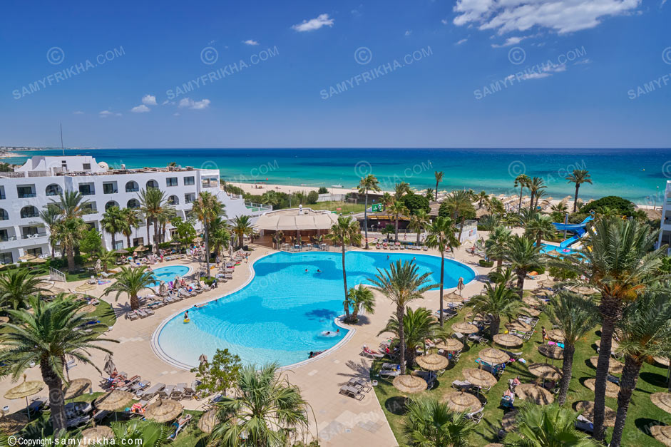 Piscine extérieure avec plage et palmiers